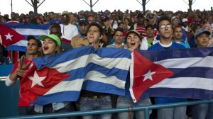 Cuban fans cheer during a baseball game between the Tampa Bay Rays and the Cuban national baseball team, in Havana, Cuba, Tuesday, March 22, 2016. The crowd roared as U.S. President Barack Obama and Cuban President Raul Castro entered the stadium and walked toward their seats in the VIP section behind home plate. It's the first game featuring an MLB team in Cuba since the Baltimore Orioles played in the country in 1999. (AP Photo/Rebecca Blackwell)